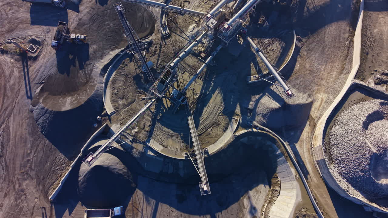 Exploring the intricate design and machinery of a sprawling construction site at midday, where conveyor systems transport materials for ongoing projects