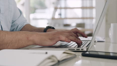 closeup of a business man typing on a laptop