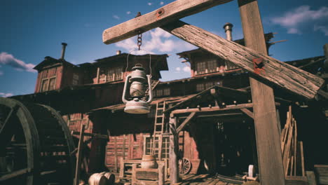 old lantern hanging in a rustic western town under a clear blue sky