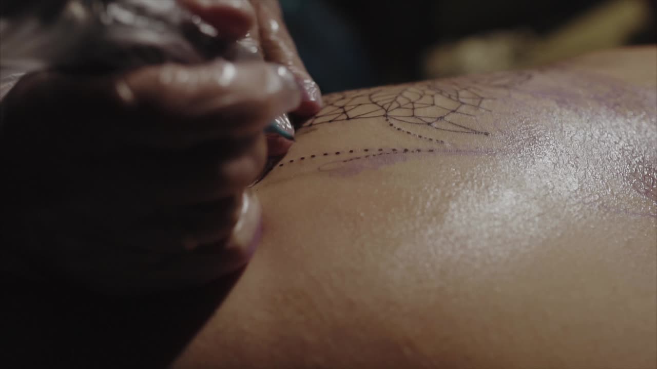 artista del tatuaje trabajando en el diseño de la telaraña