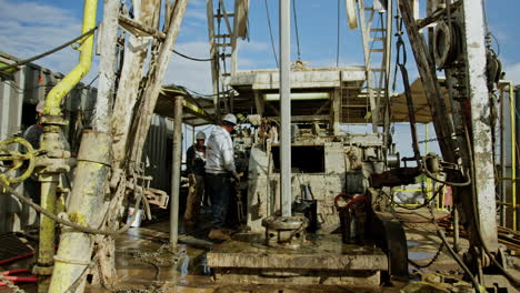 equipment for drilling oil and gas. men work at the site for production minerals.