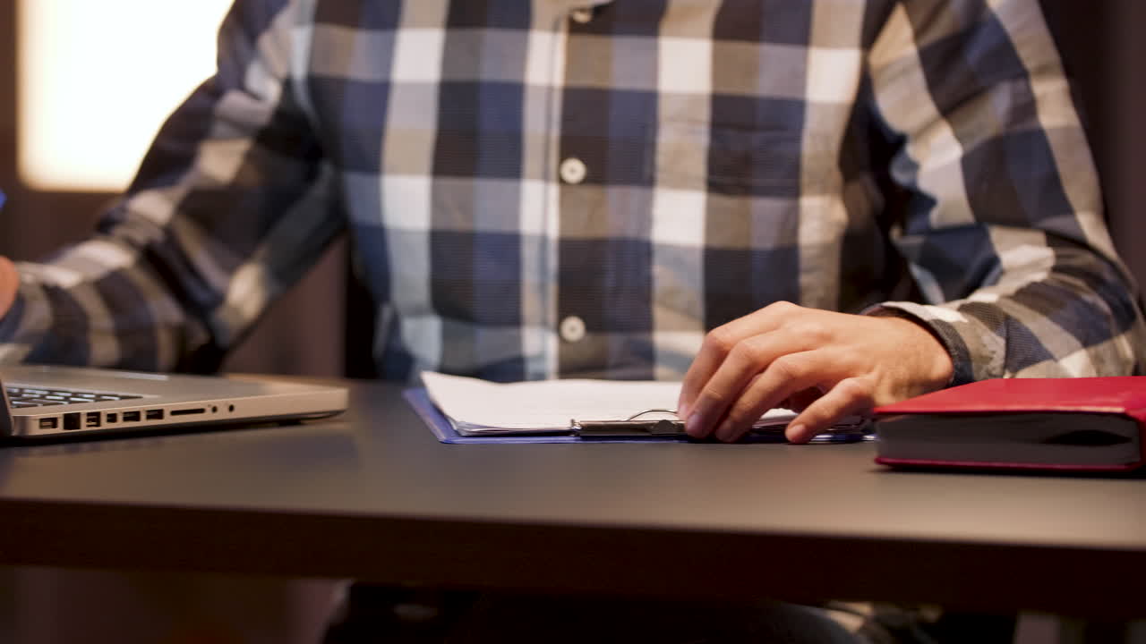 Man working at desk with laptop and paperwork