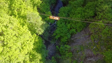 transporting an emergency stretcher on a zip line on a rough terrain drone shot