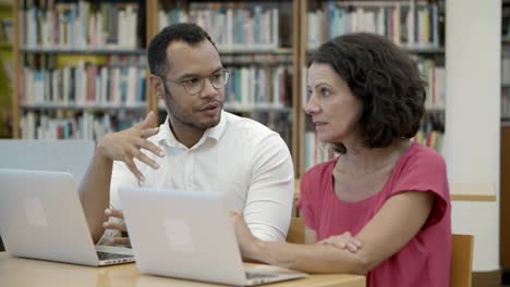 Toma-En-Cámara-Lenta-De-Dos-Personas-Hablando-En-La-Biblioteca