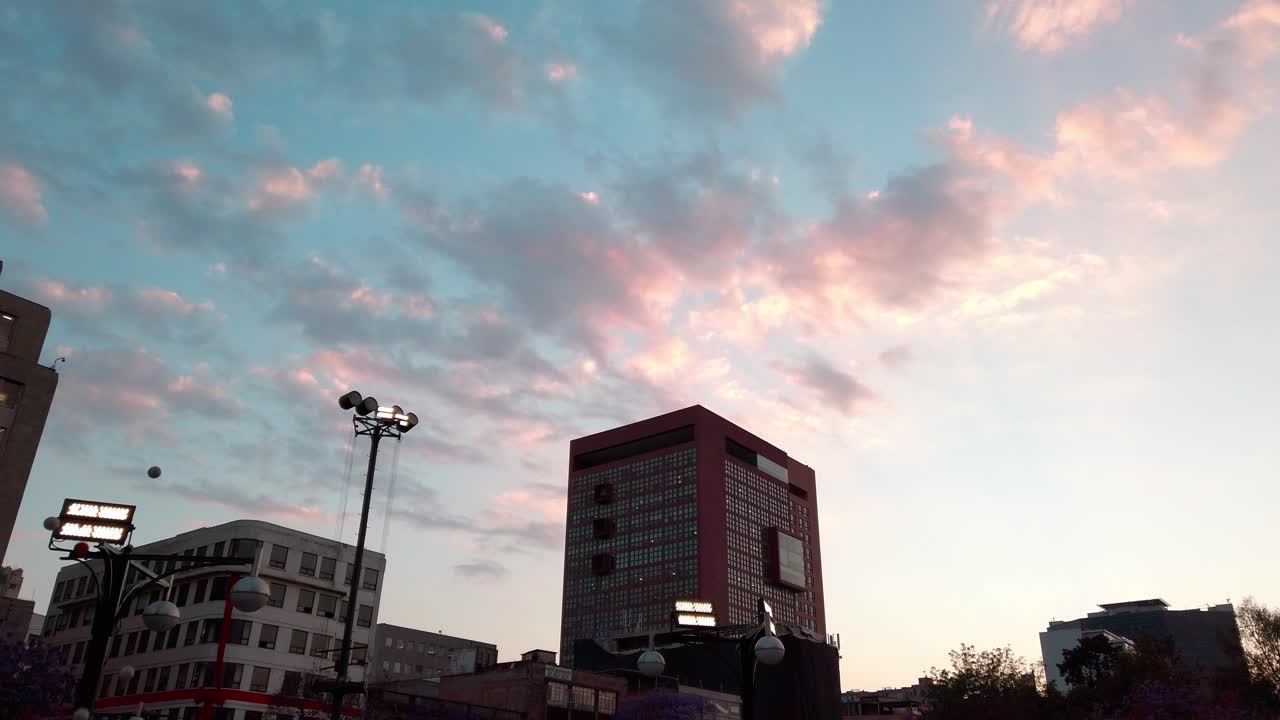 City buildings under colorful sunset sky, soft light and relaxed city vibe