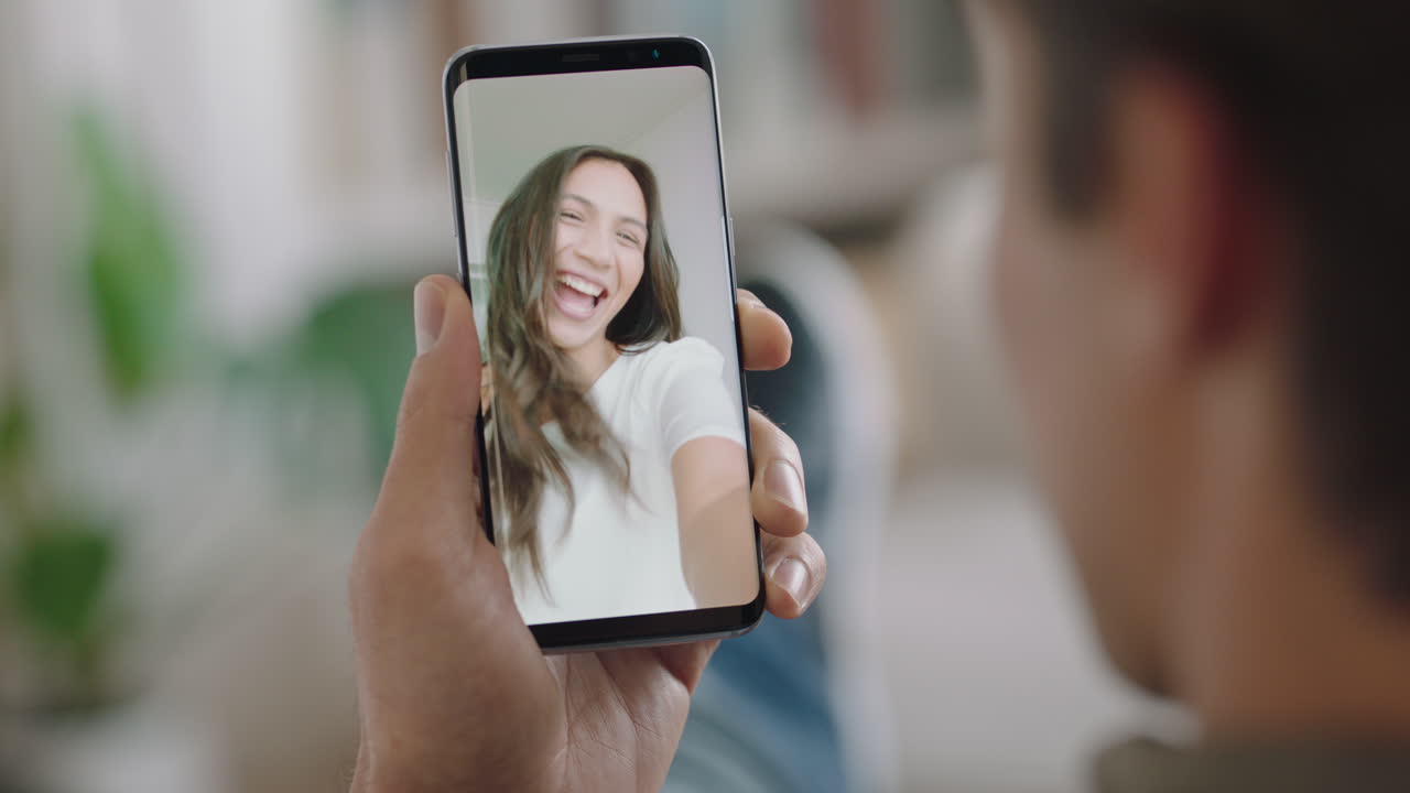 joven chateando por video usando un teléfono inteligente chateando con su novia en la pantalla disfrutando de la conversación compartiendo estilo de vida en el teléfono móvil relación a larga distancia orientación vertical 4k