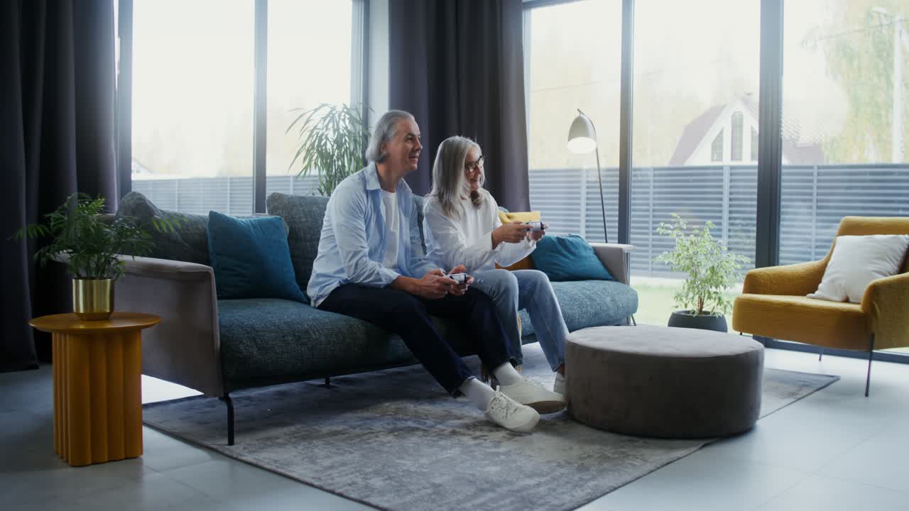 Mature couple playing video games in living room