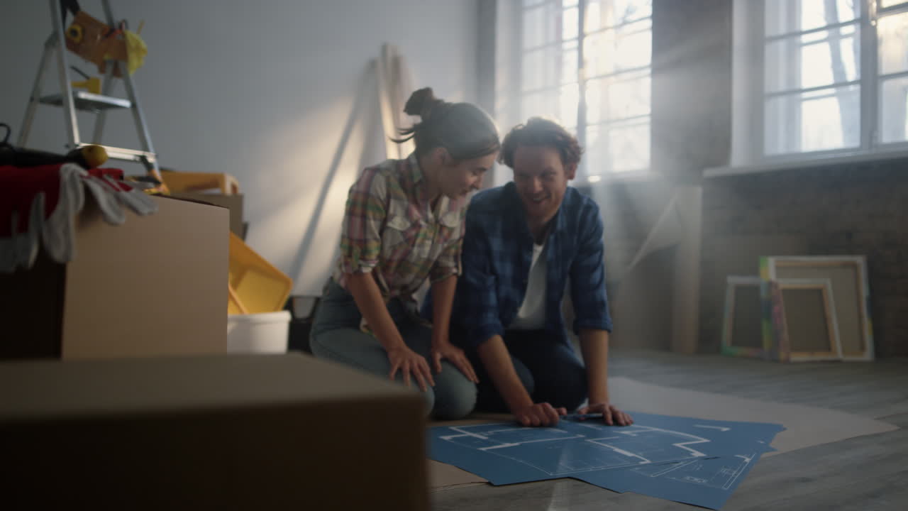 una pareja feliz coqueteando durante la renovación de la casa. la familia hablando en el interior.