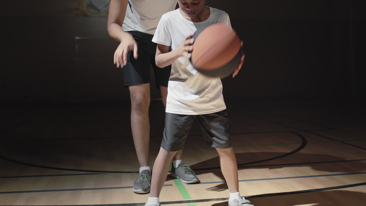 Basketball Player Teaching Son How to Dribble Ball