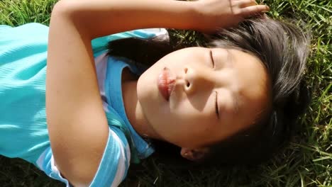 cute young girl lying on grass in park