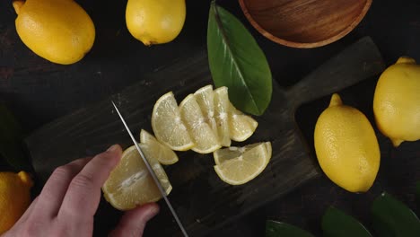 hands men cut fresh lemon into slices on a cutting board.