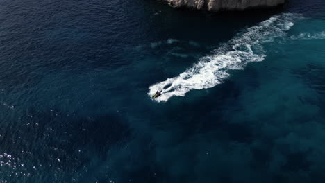 aerial drone footage of jet ski in the sea during summer