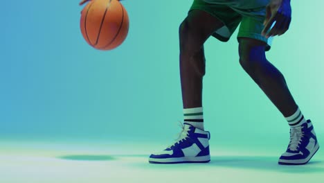 video of african american male basketball player bouncing ball on blue background