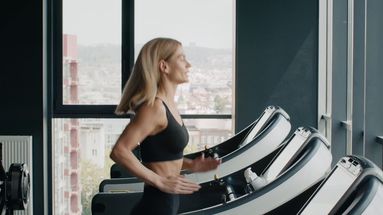 Donna che corre sul tapis roulant in palestra