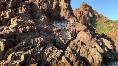 Paisaje-Rocoso-Prehistórico-De-La-Reserva-Natural-Marina-De-La-Península-De-Scandola-En-La-Temporada-De-Verano-Visto-Desde-Un-Barco-En-Movimiento,-Isla-De-Córcega-En-Francia