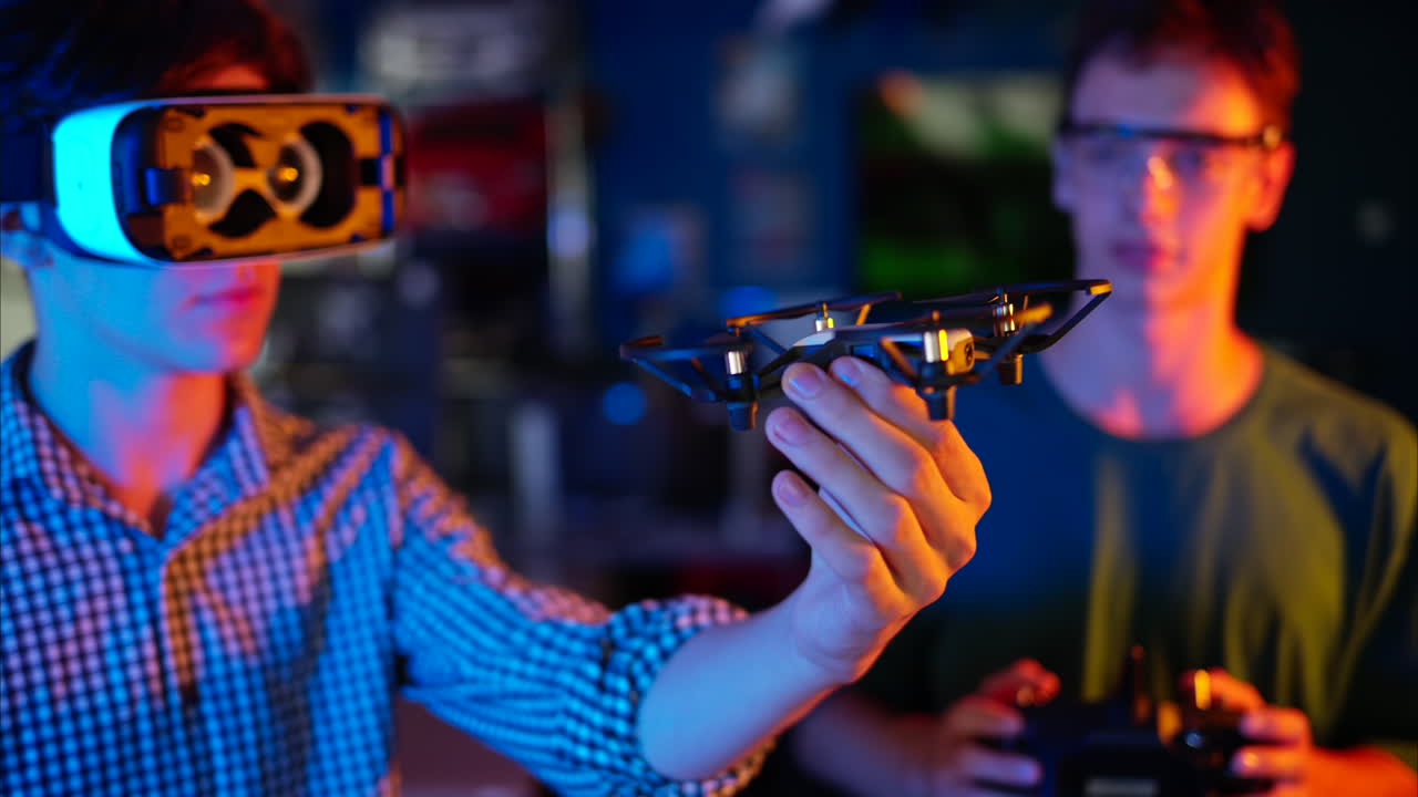 Young engineers with VR virtual reality headset controlling fliying drone in research laboratory, slow motion