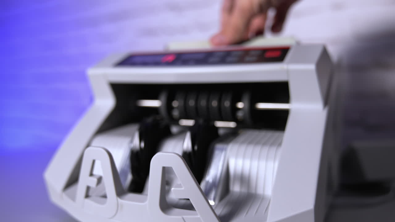 Electronic machine counting hundred dollar bills. Modern automatic equipment for counting paper currency. Money counting machine for banking and commercial activity. Slow motion.