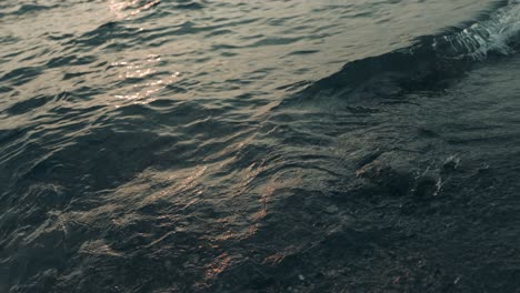 toma en cámara lenta de olas del océano ancho con reflejo solar durante el hermoso amanecer en segundo plano