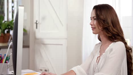 Pretty-brunette-using-her-computer