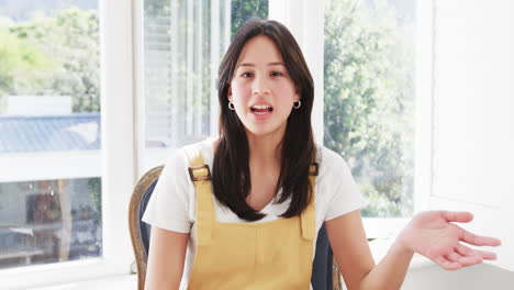 happy biracial woman having video call talking and gesturing in sunny room, copy space, slow motion