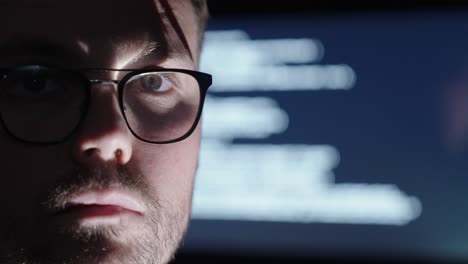 man with glasses nodding, with an ai display behind him showing code or writing. dark and deep