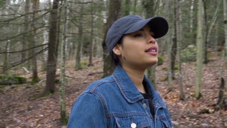 beautiful young woman hiking through forest walks past camera close up