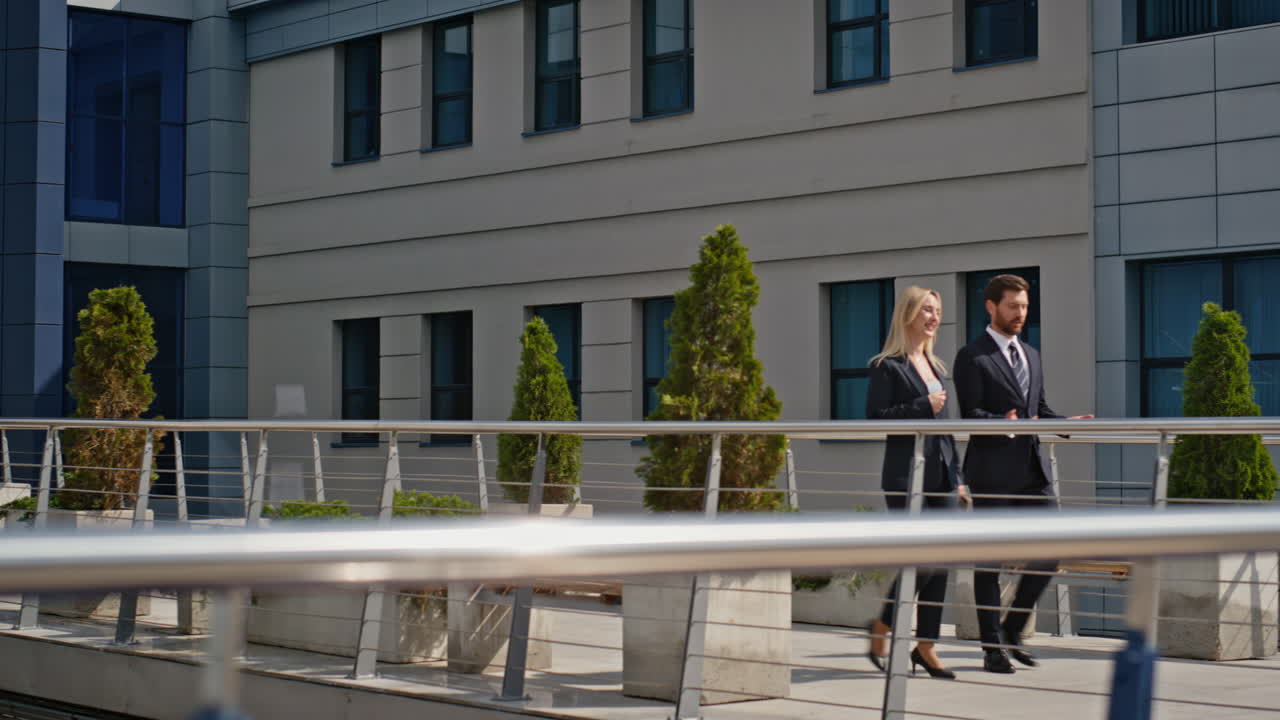 Business partners walking outside office building. Colleagues discussing plans