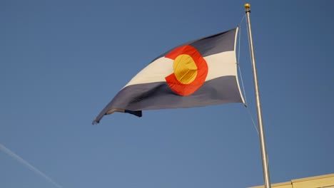 Colorado-State-flag-waving-in-the-wind-against-a-blue-sky