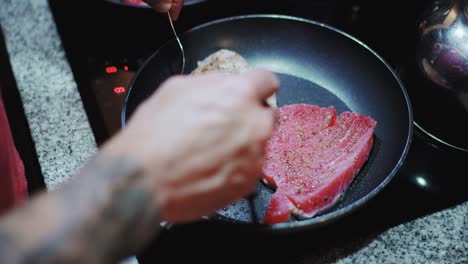 cooking big tuna steaks with spices and herbs in pan for a keto dinner