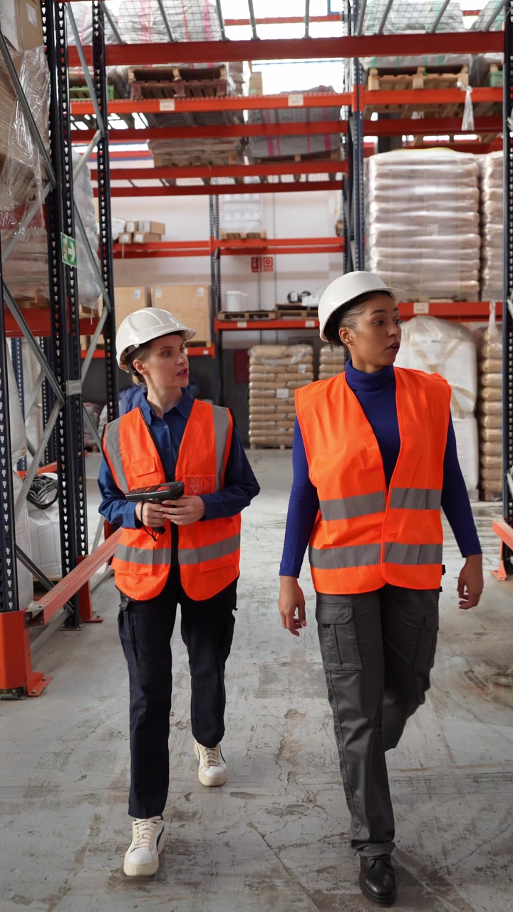 Two Warehouse Workers Walking and Talking in Distribution Center