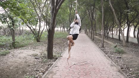 a sporty gymnast performs exercises with a rope in sportswear