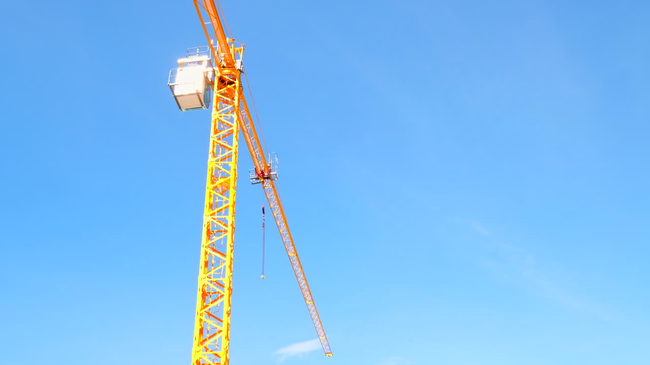 Skyward view of bright yellow construction crane on-site at new development