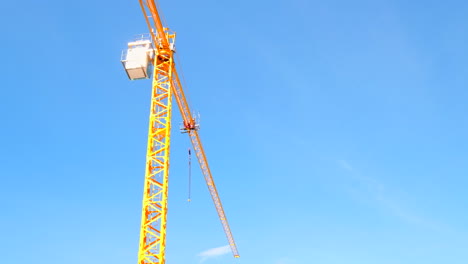 skyward view of bright yellow construction crane on-site at new development