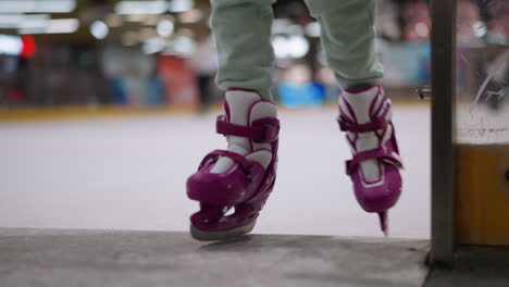 close-up view of a person wearing purple ice skates stepping onto the ice rink, the background is blurred, highlighting the lights and the dynamic environment of the skating rink