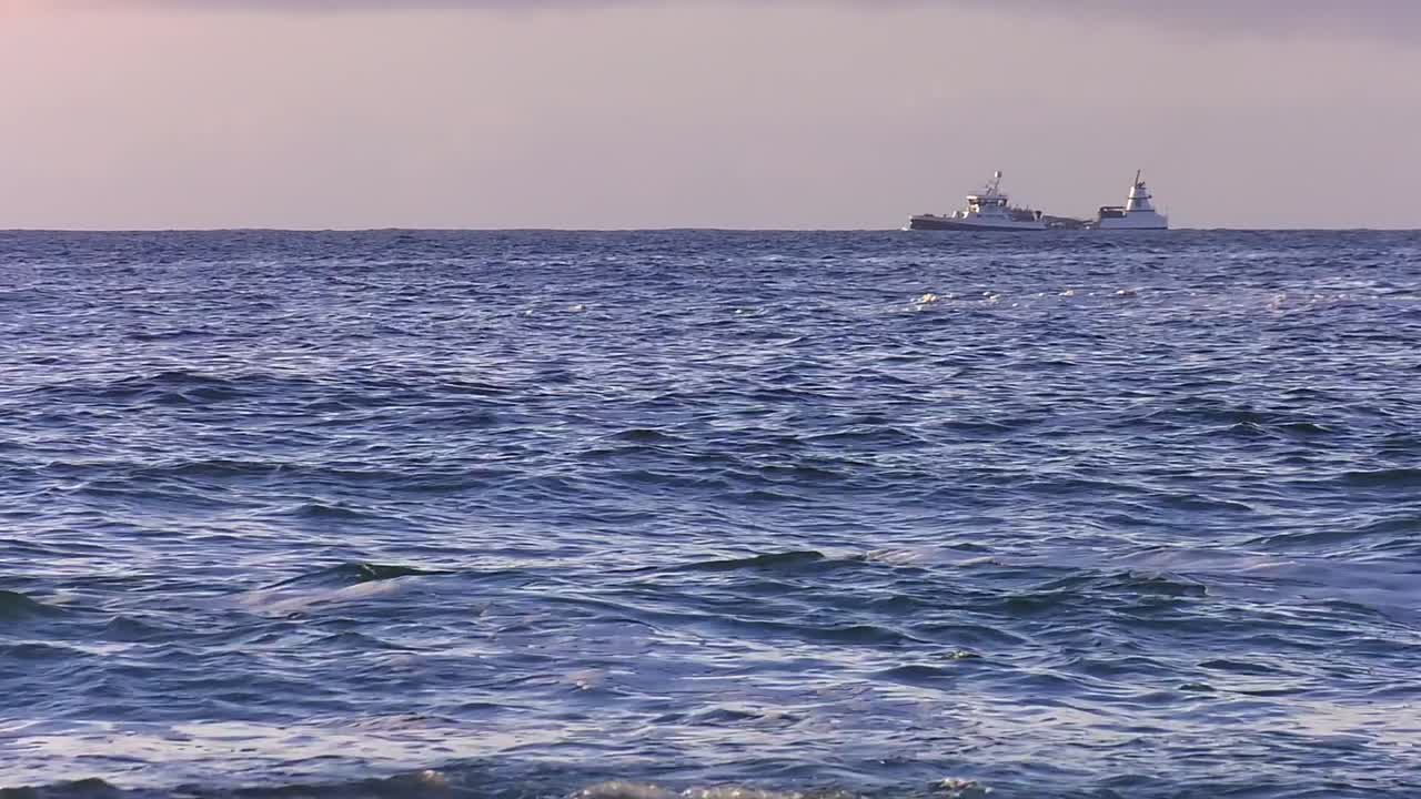 지평선을 가로질러 달리는  ⁇ 시 보트의 해가 지는 장면