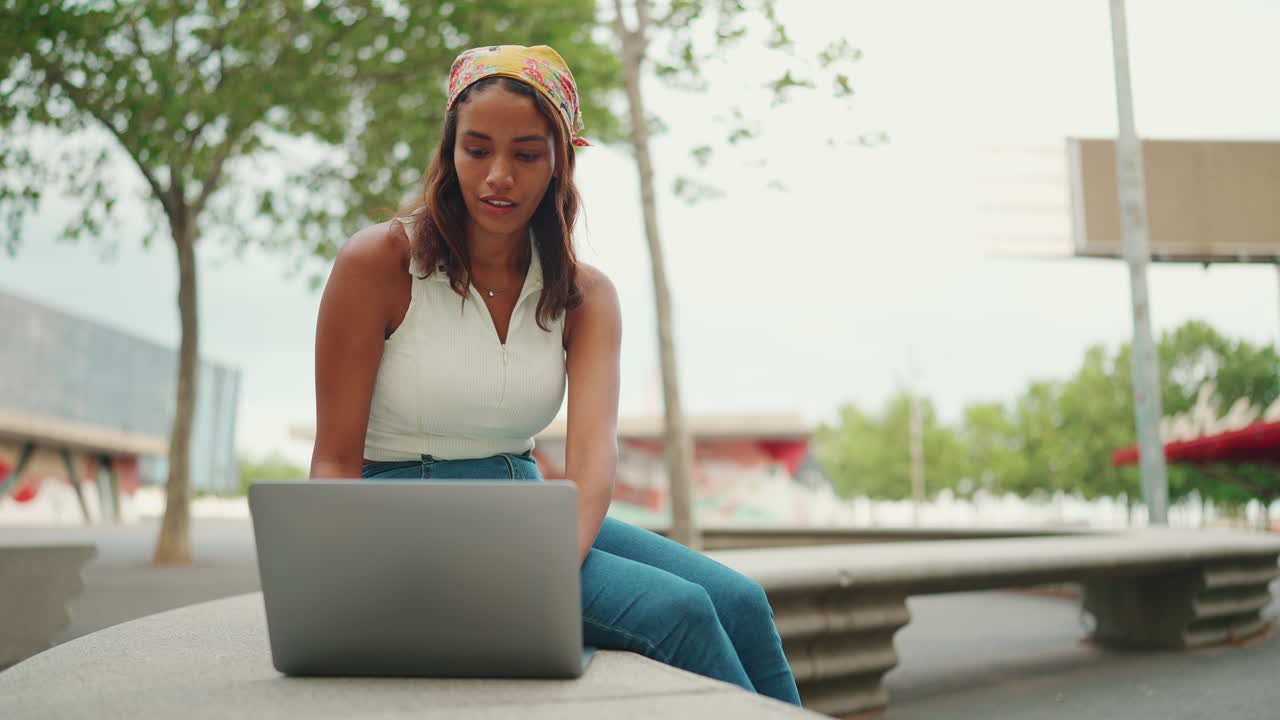 Woman working on laptop outdoors