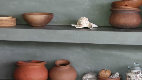 ollas de barro de diseño rústico, posavasos de madera, tazón con conchas exhibidas en una tienda en sri lanka