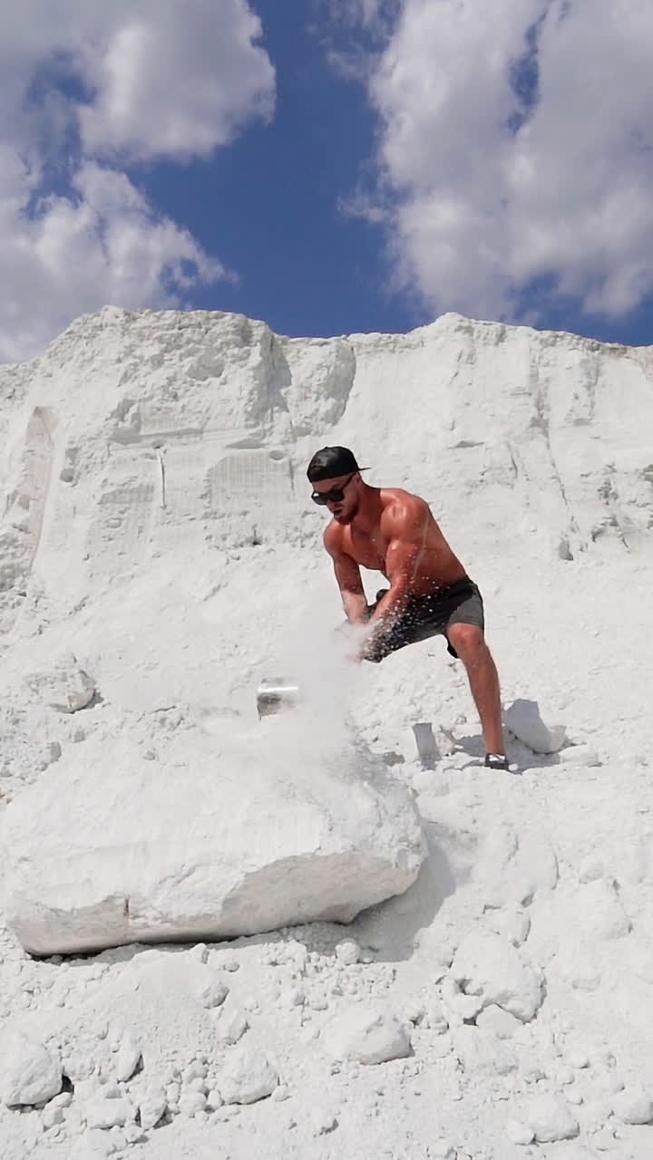 Man Hitting Stone With Hammer. Strong sport man with naked torso hitting stone with hammer during training outdoor Vertical video