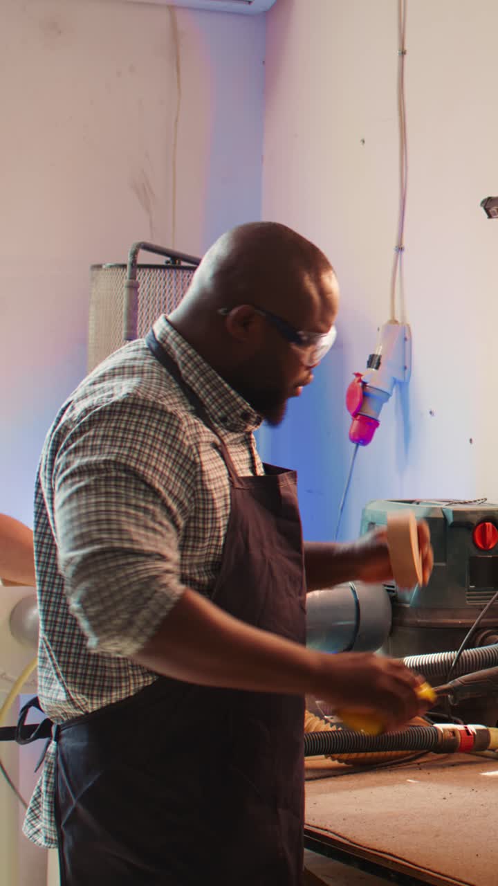 African American Carpenter Sanding Wooden Piece in Workshop