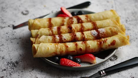 Plate-of-delicious-crepes-roll-with-fresh-fruits-and-chocolate