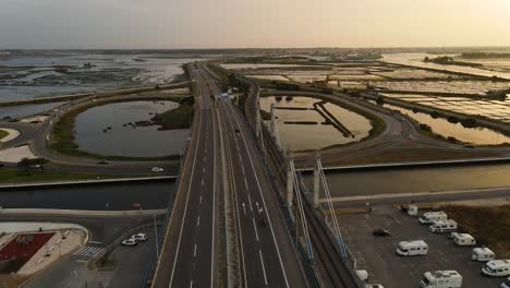 aerial footage of a highway bridge and its surrounding river channels and salt plans in aveiro, portugal