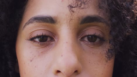 close up video portrait of eyes of happy biracial woman smiling to camera