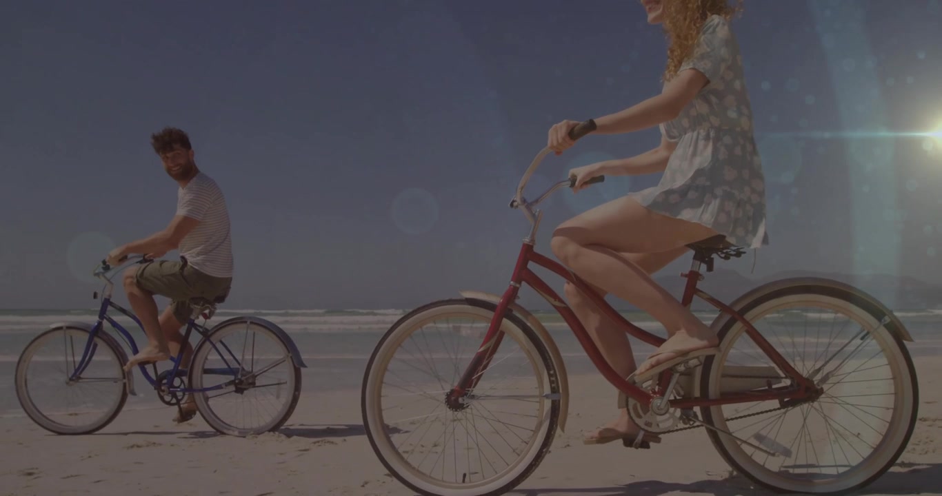 Uomo che inizia un giro in bicicletta lungo la costa, con una donna che si unisce con una bicicletta rossa e pedalano in sincronia per viaggiare.