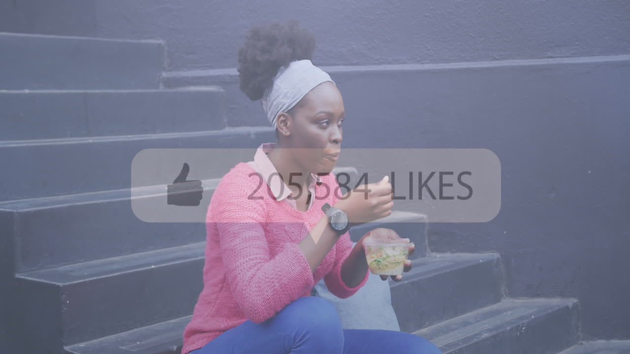 Animation of social media notification over african american woman eating takeaway sitting in street
