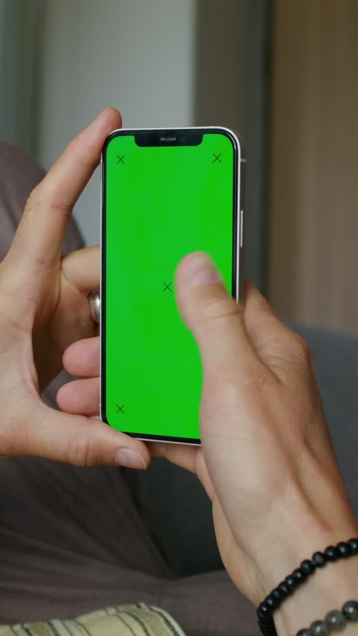 manos sosteniendo un teléfono inteligente con pantalla verde