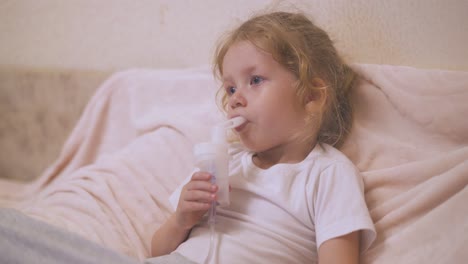 little girl has procedure with inhaler to cure cough in room