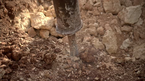 movimiento lento de cerca de un martillo hidráulico perforación martillo rocas expulsando polvo y escombros como explosiones