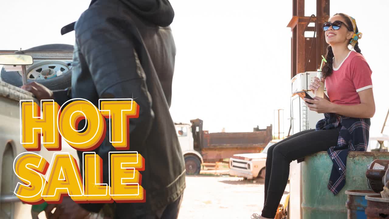 Animation of hot sale text in orange over diverse man and woman using fuel pump at petrol station