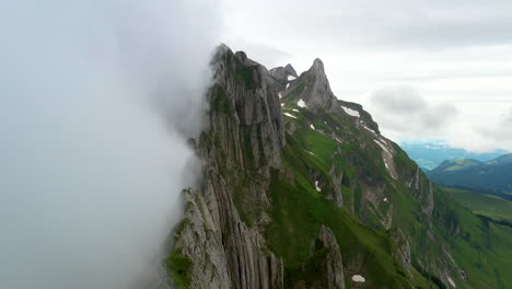 Cinematic-drone-shot-starting-in-the-clouds-then-revealing-Altenalp-Turm-in-Switzerland