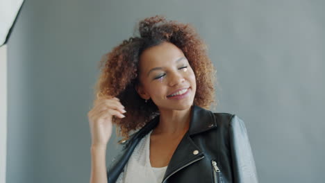 stylish woman with curly hair in a black leather jacket